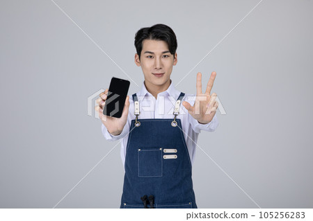 millennials and gen z, korean asian young man holding a smartphone millennials and gen z, korean asian young man holding a smartphone 105256283