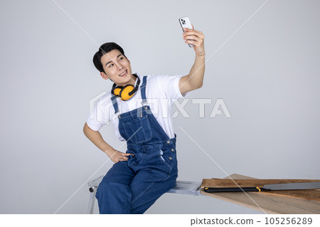 millennials and gen z, korean asian young man carpenter taking selfie 105256289