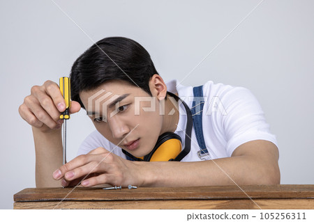 millennials and gen z, korean asian young man carpenter screwing 105256311