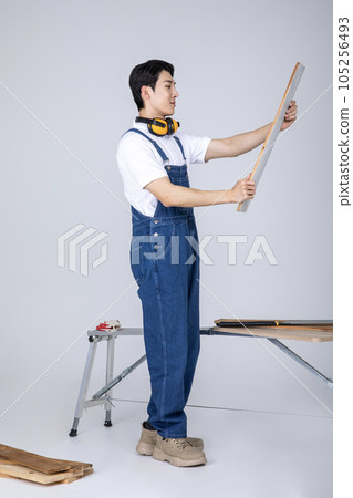 millennials and gen z, korean asian young man carpenter holding a board 105256493