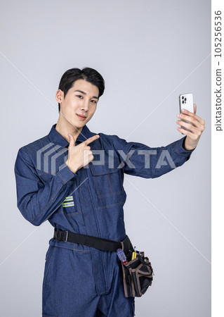 millennials and gen z, korean asian young man, site staff with a smartphone millennials and gen z, korean asian young man, site staff with a smartphone 105256536