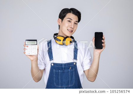 millennials and gen z, korean asian young man carpenter holding a calculator and a smartphone 105256574