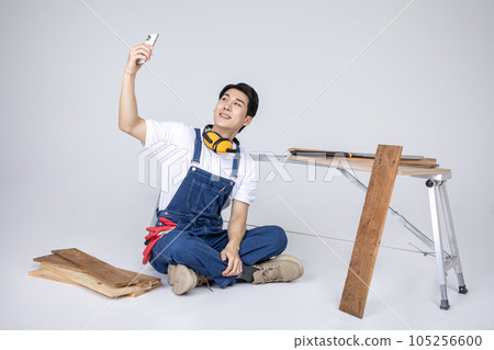 millennials and gen z, korean asian young man carpenter taking selfie millennials and gen z, korean asian young man carpenter taking selfie 105256600