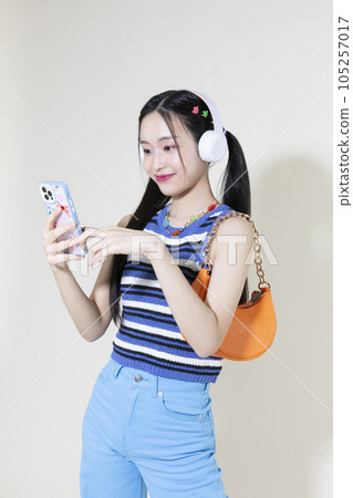 vintage y2k retro concept photo of korean asian cute woman wearing a headphones and selecting music 105257017