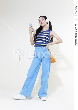 vintage y2k retro concept photo of korean asian cute woman wearing a headphones and selecting music vintage y2k retro concept photo of korean asian cute woman wearing a headphones and selecting music 105257079