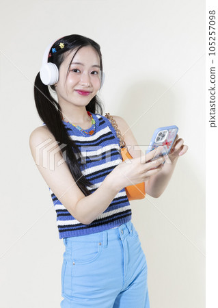 vintage y2k retro concept photo of korean asian cute woman wearing a headphones and selecting music vintage y2k retro concept photo of korean asian cute woman wearing a headphones and selecting music 105257098