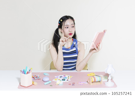 vintage y2k retro concept photo of korean asian cute woman with pen and diary 105257241