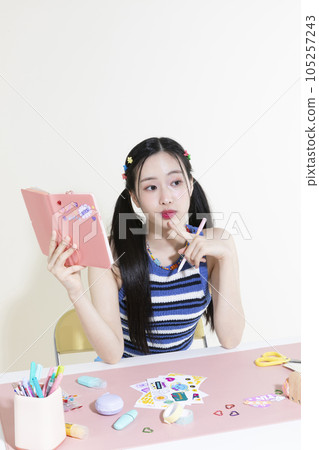 vintage y2k retro concept photo of korean asian cute woman with pen and diary 105257243