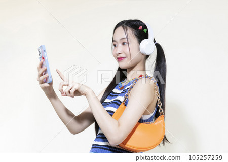vintage y2k retro concept photo of korean asian cute woman wearing a headphones and selecting music vintage y2k retro concept photo of korean asian cute woman wearing a headphones and selecting music 105257259
