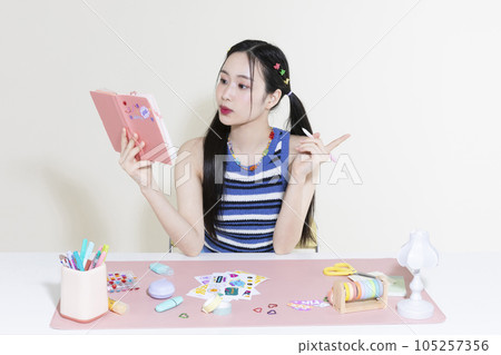 vintage y2k retro concept photo of korean asian cute woman with pen and diary 105257356