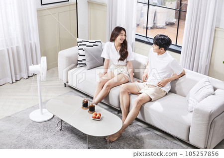 summer lifestyle, korean asian young couple sitting on couch and facing each other 105257856