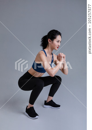 healthy beauty concept photo of korean asian beautiful woman doing squats healthy beauty concept photo of korean asian beautiful woman doing squats 105257877