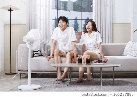 summer lifestyle, korean asian young couple enjoying fan breeze 105257893