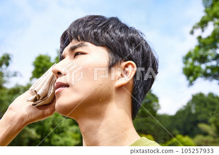 summer lifestyle, korean asian young man wiping sweat outdoor summer lifestyle, korean asian young man wiping sweat outdoor 105257933