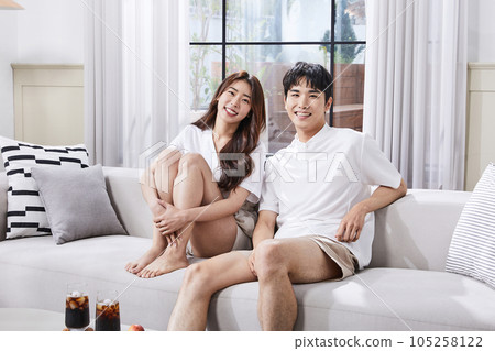 summer lifestyle, korean asian young couple sitting on couch and facing each other 105258122