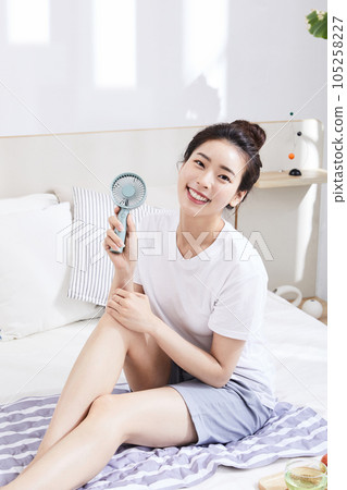 summer lifestyle, korean asian young woman with bed and fan 105258227