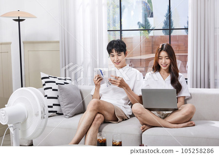 summer lifestyle, korean asian young couple enjoying fan breeze 105258286