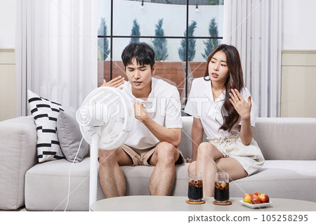 summer lifestyle, korean asian young couple enjoying fan breeze 105258295