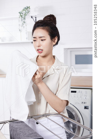 summer lifestyle, korean asian young woman concerned about the smell of laundry summer lifestyle, korean asian young woman concerned about the smell of laundry 105258348