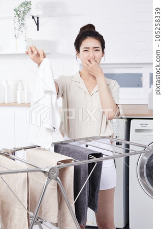 summer lifestyle, korean asian young woman concerned about the smell of laundry summer lifestyle, korean asian young woman concerned about the smell of laundry 105258359