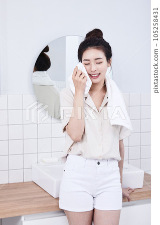 summer lifestyle, korean asian young woman leaning on the bathroom sink and wiping face 105258431