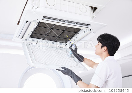 summer lifestyle, korean asian young man cleaning the air conditioner 105258445