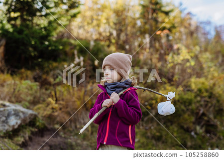 Portrait of little girl with bindle during autumn hike in mountains. 105258860