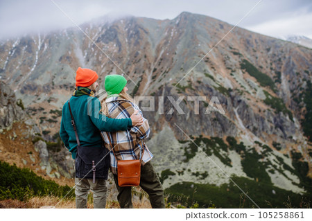 Young happy couple at mountain hike, hugging each other. 105258861
