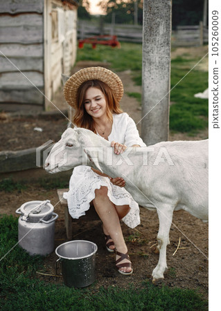 Girl farmer with white goat. Woman and small goat green grass. Eco farm. Farm and farming concept. Village animals. Girl farmer with white goat. Woman and small goat green grass. Eco farm. Farm and farming concept. Village animals. 105260009