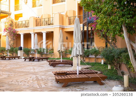 View of the pool, palm trees and the reflection of the sun on the castle grounds in Egypt - the concept of a luxury trip. View of the pool, palm trees and the reflection of the sun on the castle grounds in Egypt - the concept of a luxury trip. 105260138