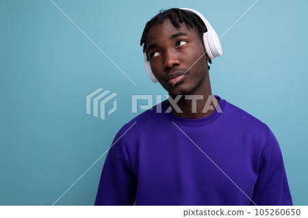 well-groomed african young brunette man with dreadlocks with wireless headphones 105260650