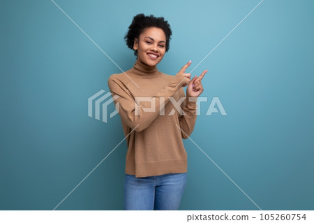 young optimistic latin woman with curly hair smiling on background with copy space 105260754