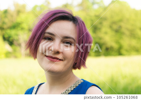 Young woman with purple hair, short haircut in nature 105261068