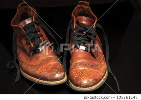 A pair of brown vintage leather shoes on a dark background. Beautiful leather shoes. Retro boots 105261143
