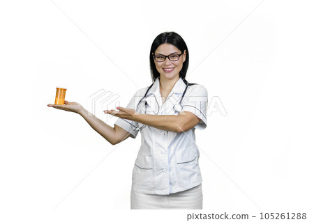 Happy young asian female doctor is holding a can of pills on her palm. Medicine advertisement concept. Isolated on white. 105261288