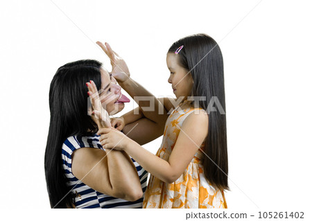 Young brunette woman plays the ape to amuse her little daughter. Showing tongue and hand ears. Isolated on white. 105261402