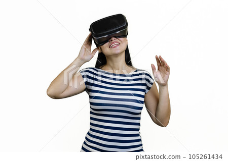 Happy young brunette woman experiencing virtual reality in headset. Isolated on white. Happy young brunette woman experiencing virtual reality in headset. Isolated on white. 105261434
