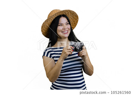 Smiling asian female tourist in straw hat is taking a photo a vintage photo camera. Isolated on white. 105261560