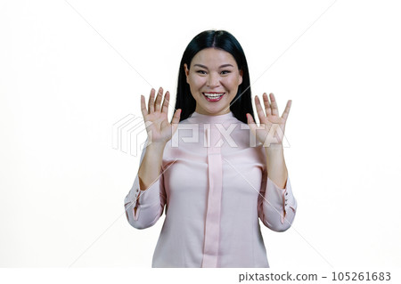 Portrait of smiling asian woman with her hands up. Isolated on white background. 105261683