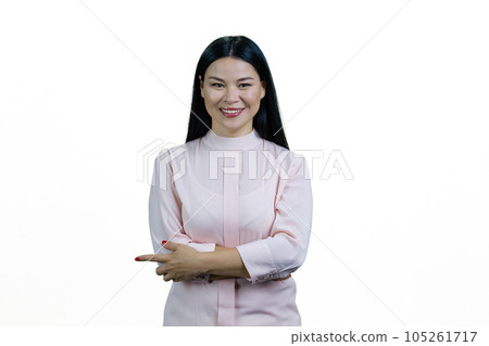 Portrait of a young asian woman with crossed arms pointing at something. Isolated on white background. Portrait of a young asian woman with crossed arms pointing at something. Isolated on white background. 105261717