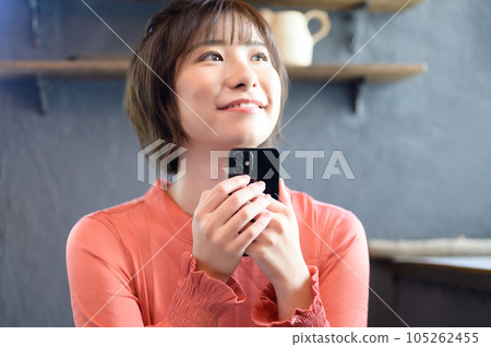 A woman looking at her smartphone at a cafe Photography cooperation "Western confectionery shop sentiment" 105262455