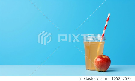 Apple juice in a transparent glass with a straw Apple juice in a transparent glass with a straw 105262572