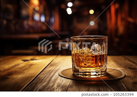 A glass of whiskey on a wooden table in a bar. A glass of whiskey on a wooden table in a bar. 105263394