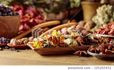 Various dried medicinal plants, herbs, and flowers on an old wooden background. 105265452
