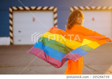 African American lesbian woman holding LGBT rainbow flag. The concept of happiness, freedom and love for same-sex couples. African American lesbian woman holding LGBT rainbow flag. The concept of happiness, freedom and love for same-sex couples. 105266739