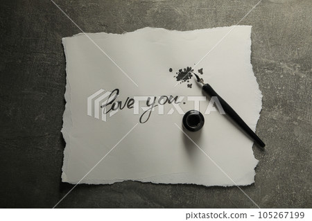 Ink bottle, pen and words Love you on paper on gray background, top view Ink bottle, pen and words Love you on paper on gray background, top view 105267199