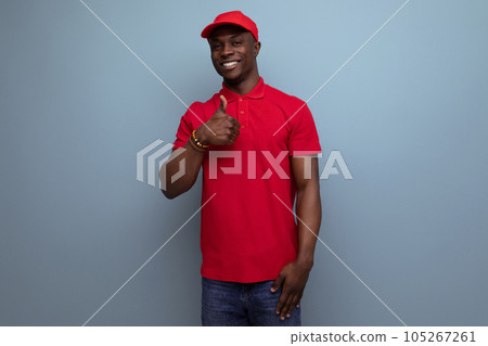 branded clothing concept. american man wearing a red t-shirt and cap on the background of ss copy branded clothing concept. american man wearing a red t-shirt and cap on the background of ss copy 105267261
