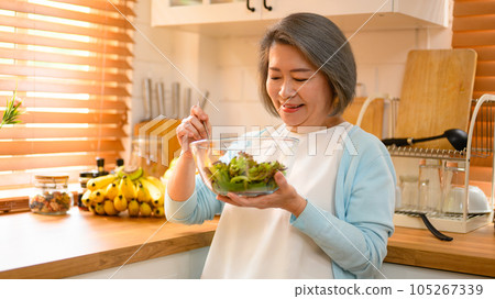 mature and old adult woman takes on the role of a skilled cooking salad. mature and old adult woman takes on the role of a skilled cooking salad. 105267339