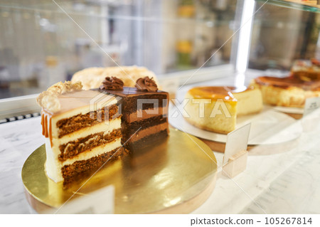 Chocolate cake with strawberries. fresh pastries with berries. A variety of fresh pastries in the bakery window. Strawberry cake. The interior of an Italian restaurant. 105267814