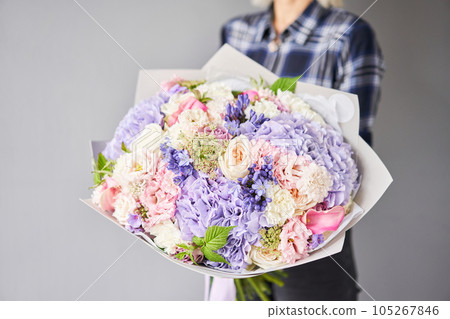 Beautiful bouquet of mixed flowers in woman hand. Floral shop concept . Beautiful fresh cut bouquet. Flowers delivery Beautiful bouquet of mixed flowers in woman hand. Floral shop concept . Beautiful fresh cut bouquet. Flowers delivery 105267846